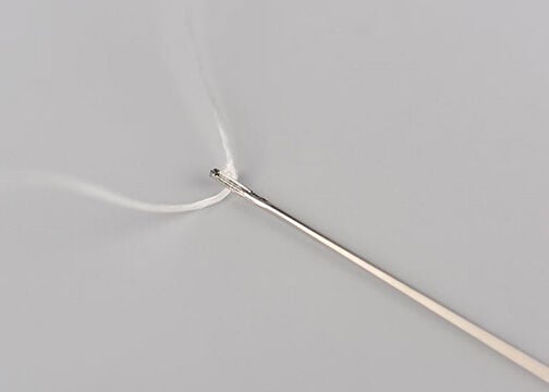 Needle strung with white thread. Thread appears blurry as if it's in motion.